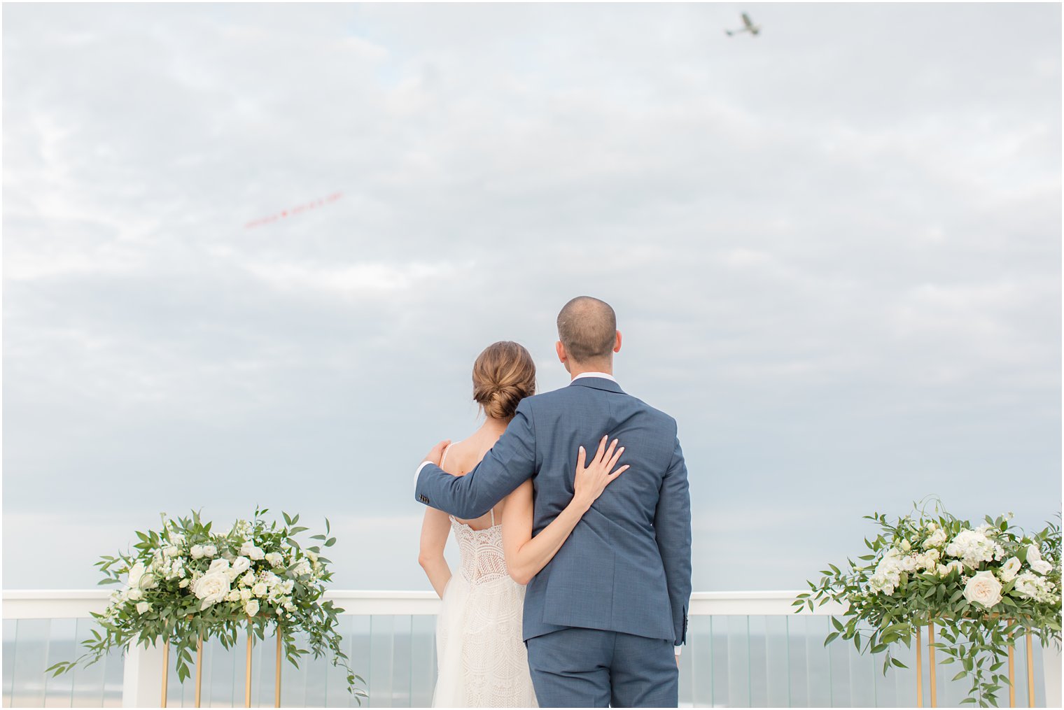 bride and groom look over beach after intimate wedding ceremony