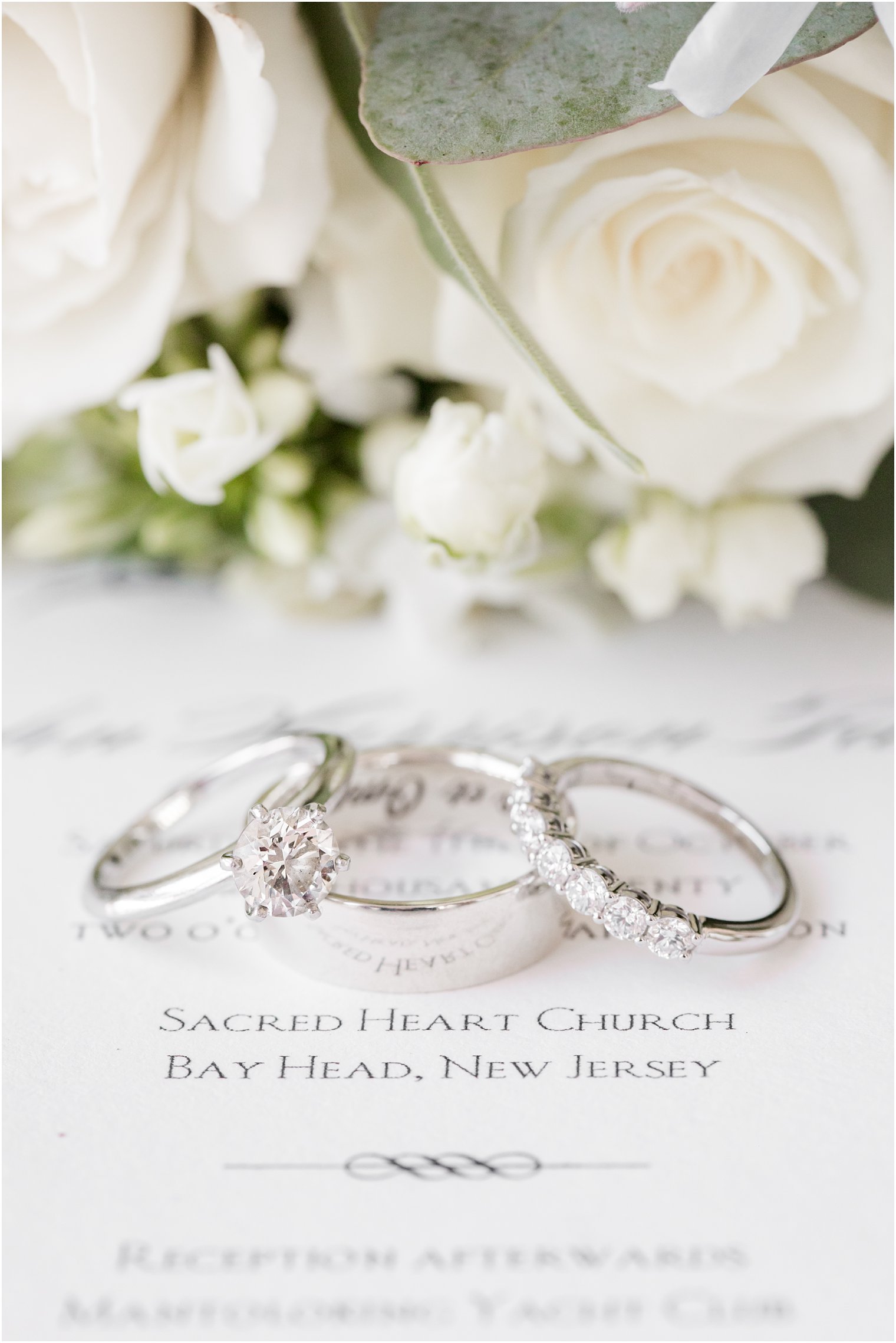 wedding rings sit on elegant invitation suite before NJ wedding