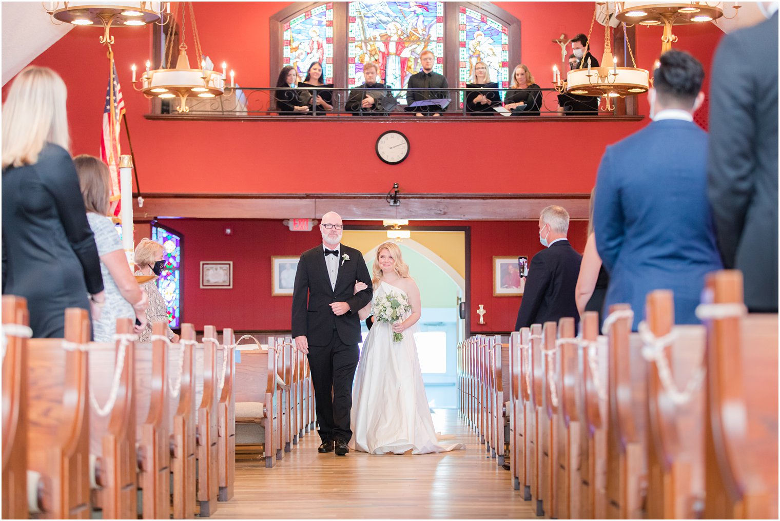 bride walks down aisle during traditional church wedding in New Jersey