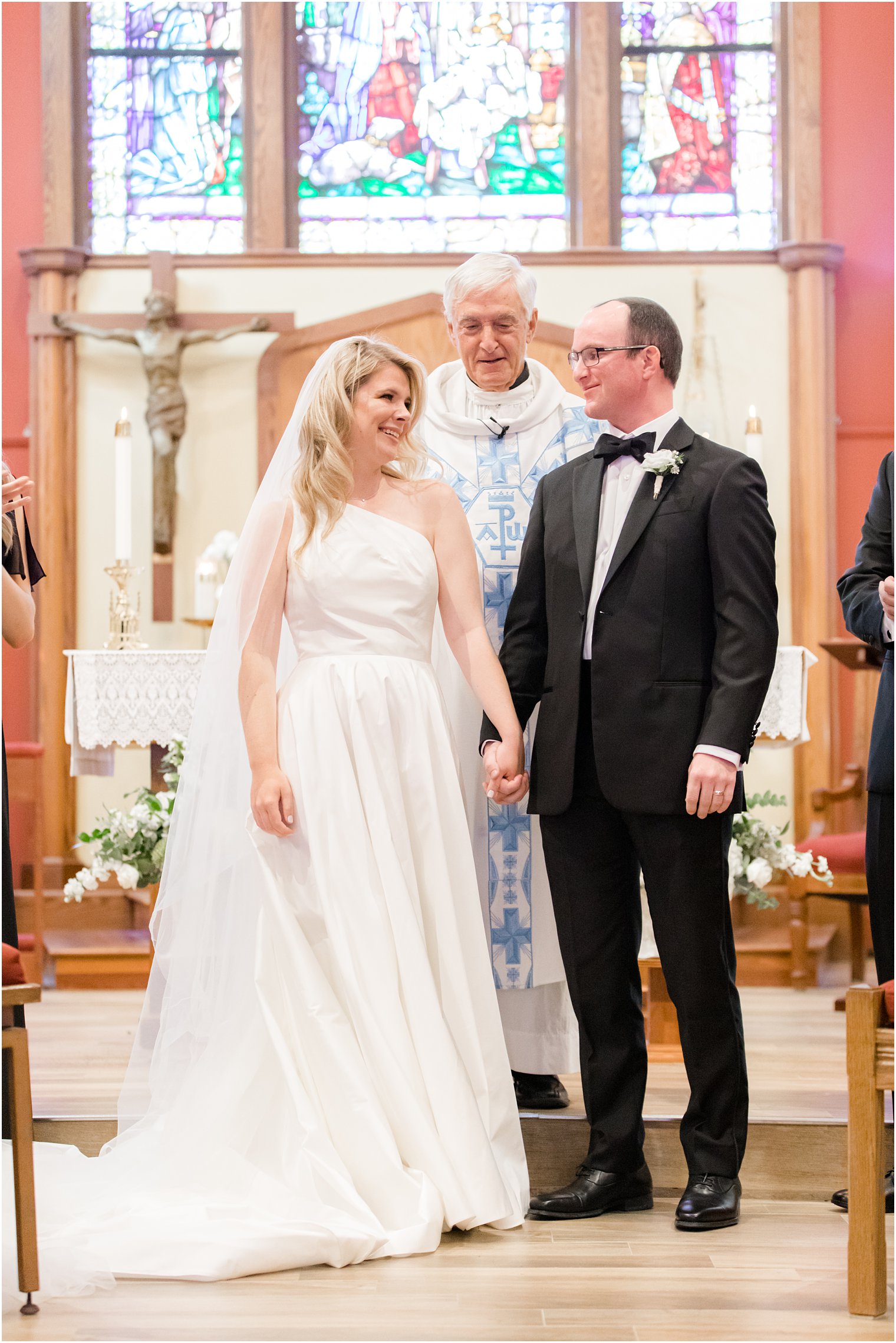 newlyweds smile at each other at end of traditional church wedding in New Jersey
