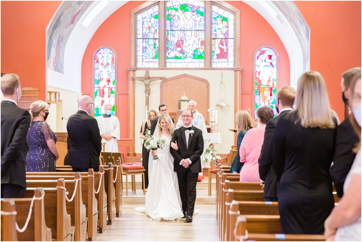 bride walks down aisle with groom after traditional church wedding in New Jersey