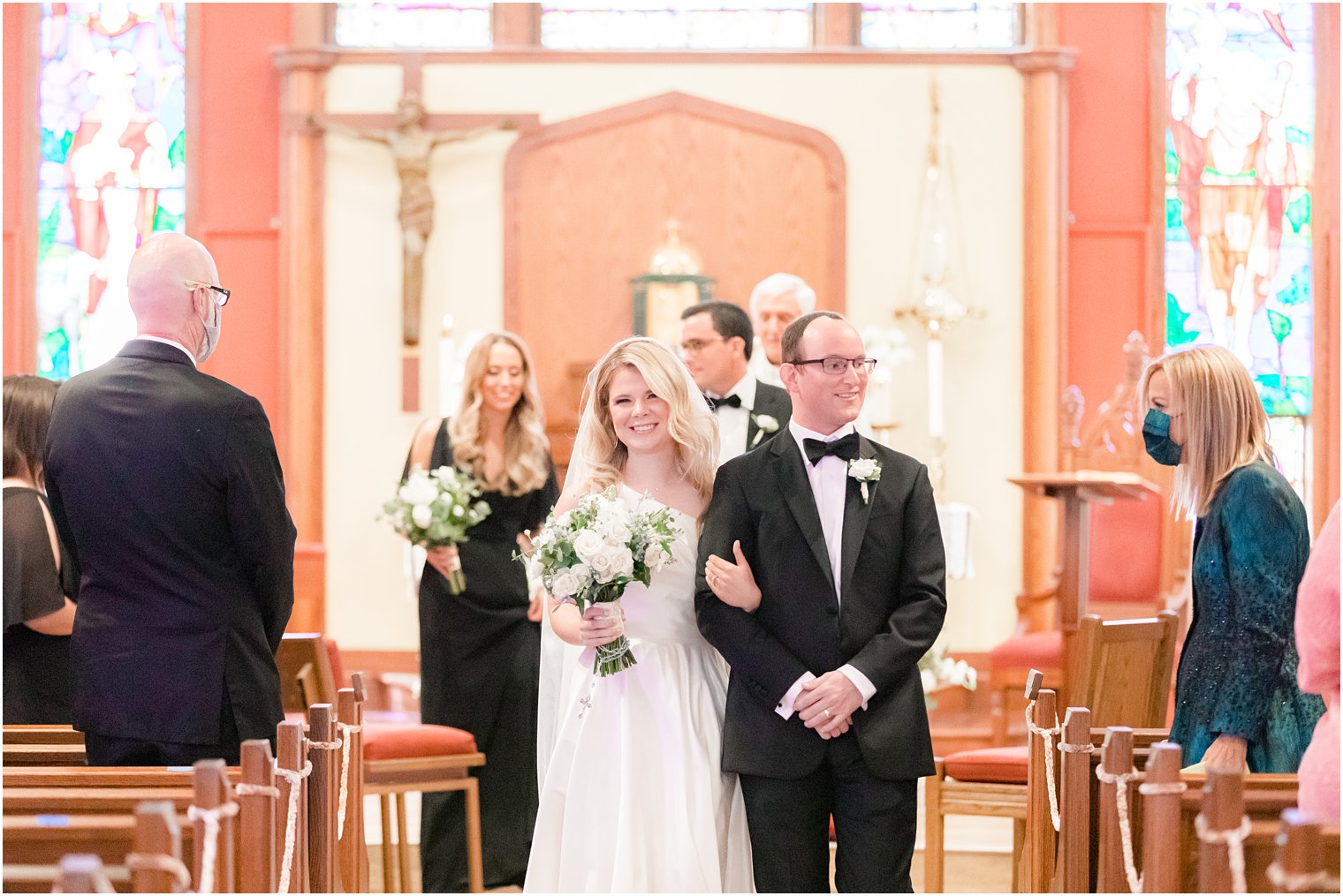 newlyweds walk down aisle after traditional church wedding in New Jersey