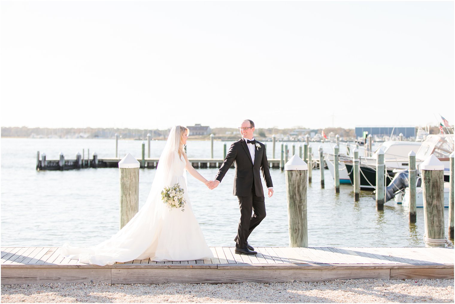 bride and groom walk along Mantoloking Yacht Club pier