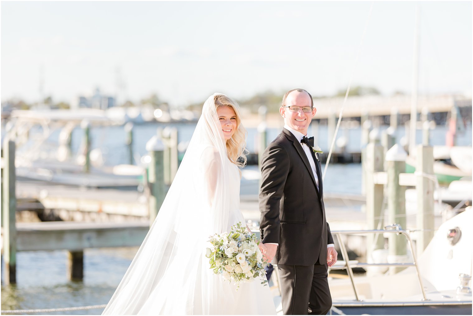bride and groom walk pier at Mantoloking Yacht Club