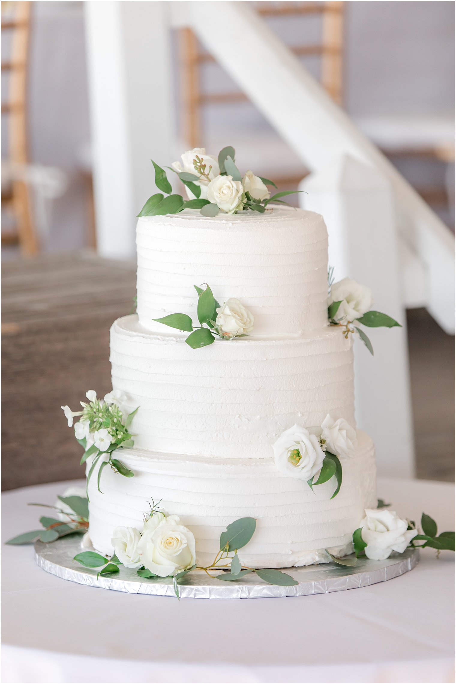 tiered wedding cake with ivory flowers for yacht club wedding