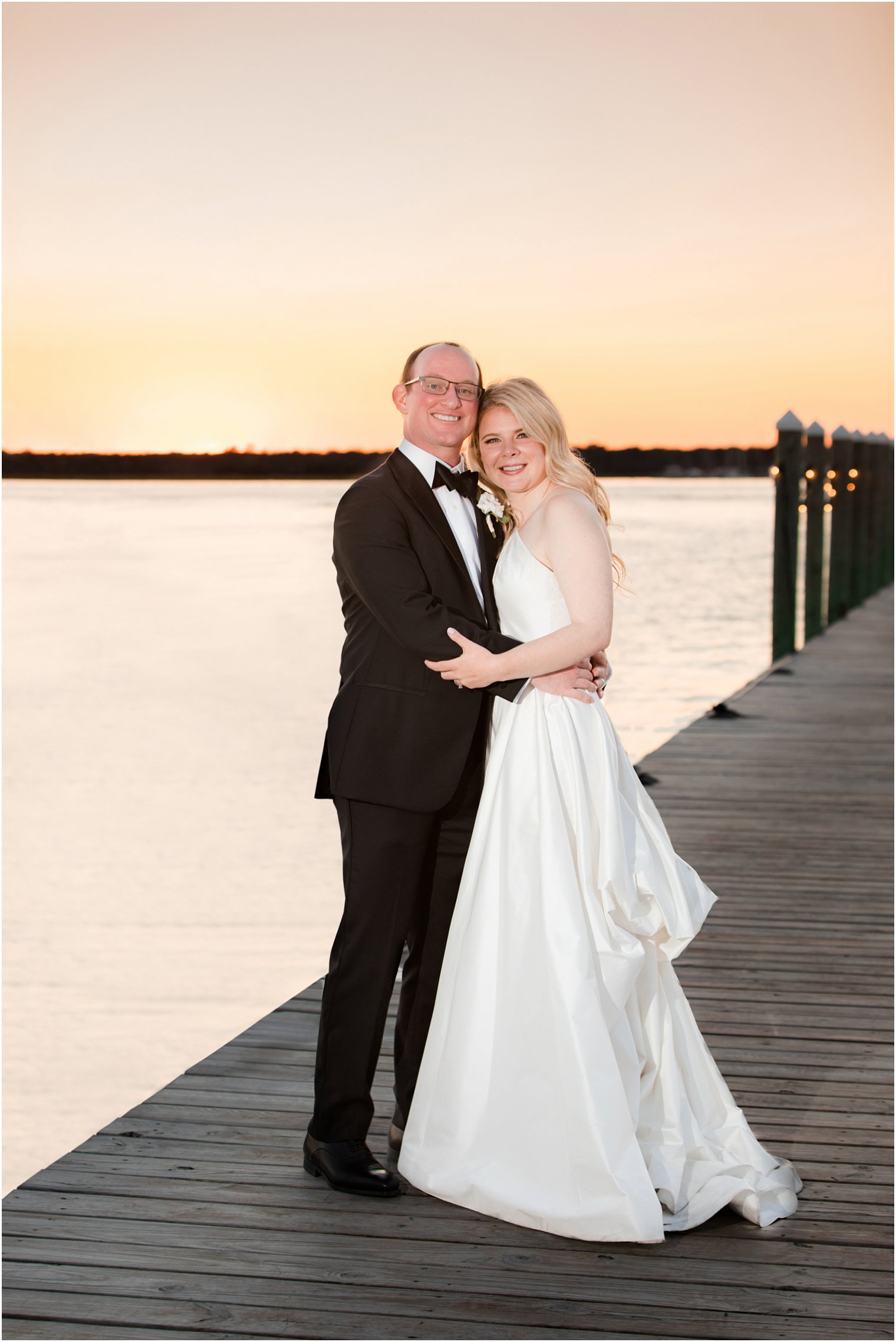 newlyweds pose at sunset by Barnegat Bay in Mantoloking
