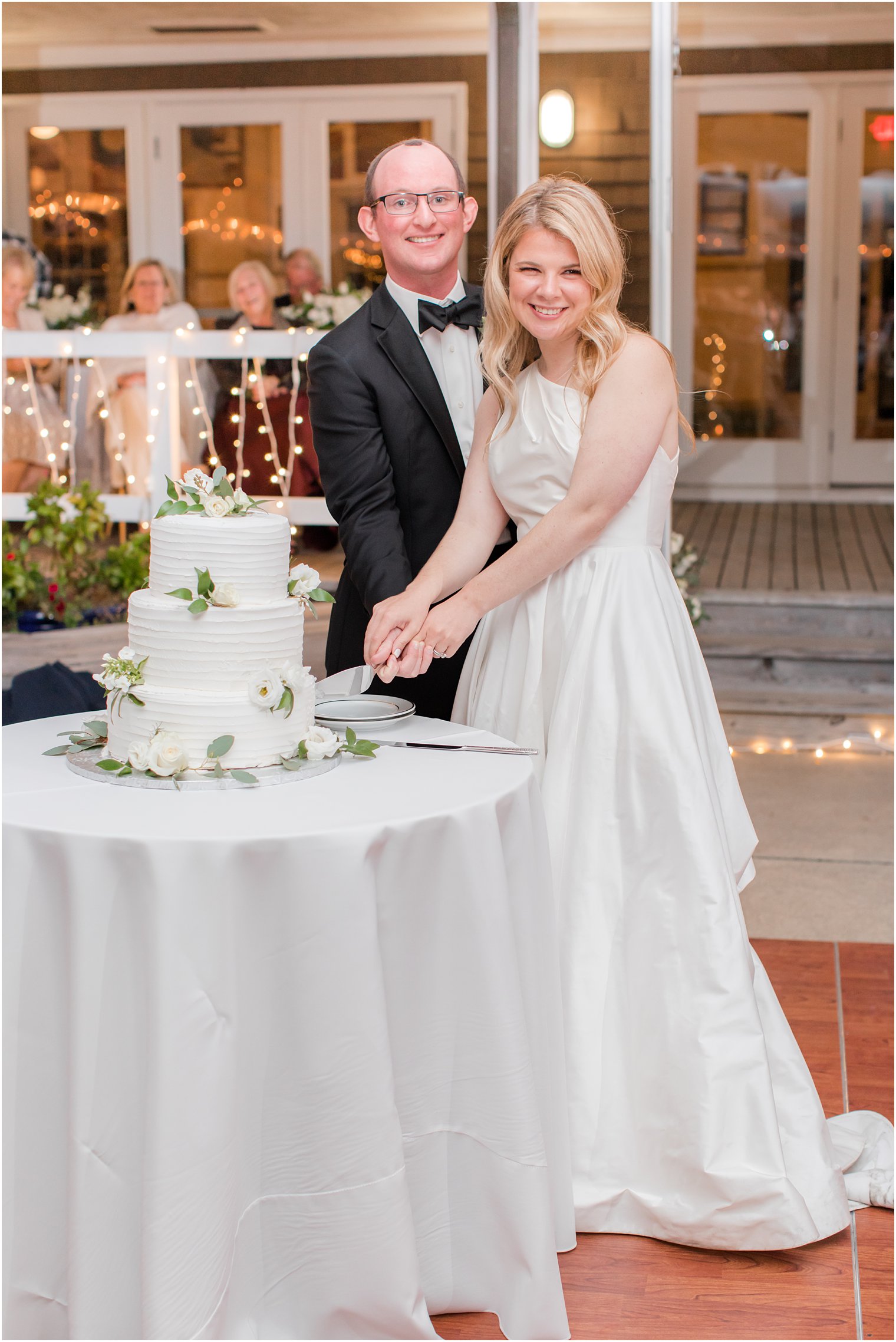 newlyweds cut wedding cake in Mantoloking NJ