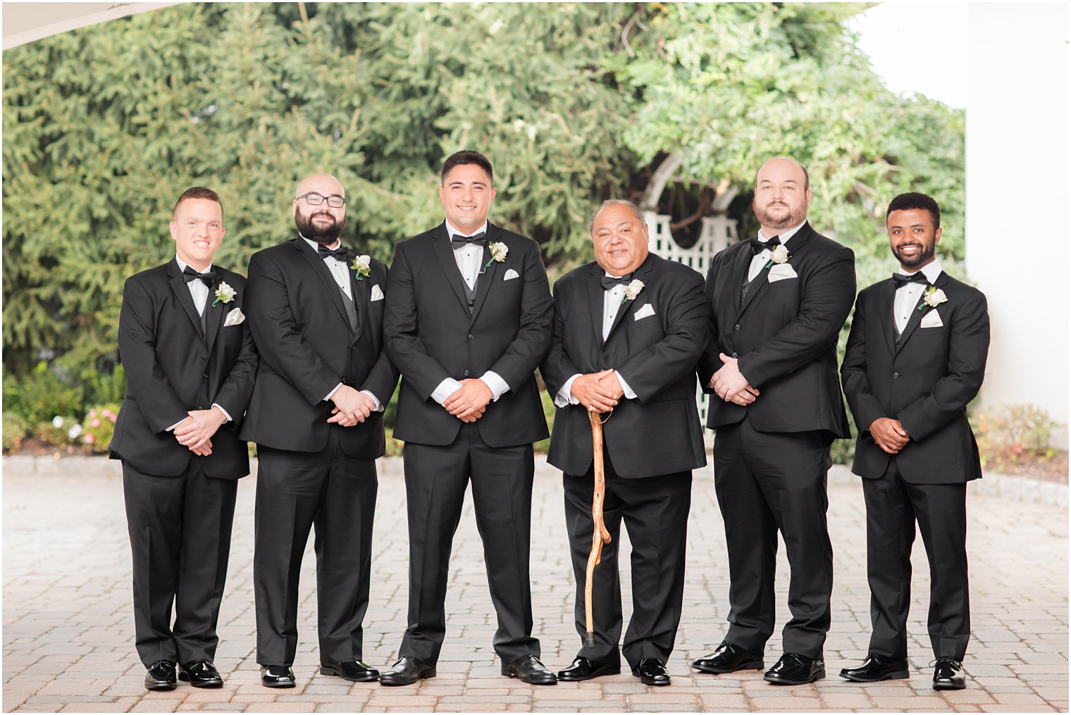 groom poses with groomsmen outside Nanina's in the Park