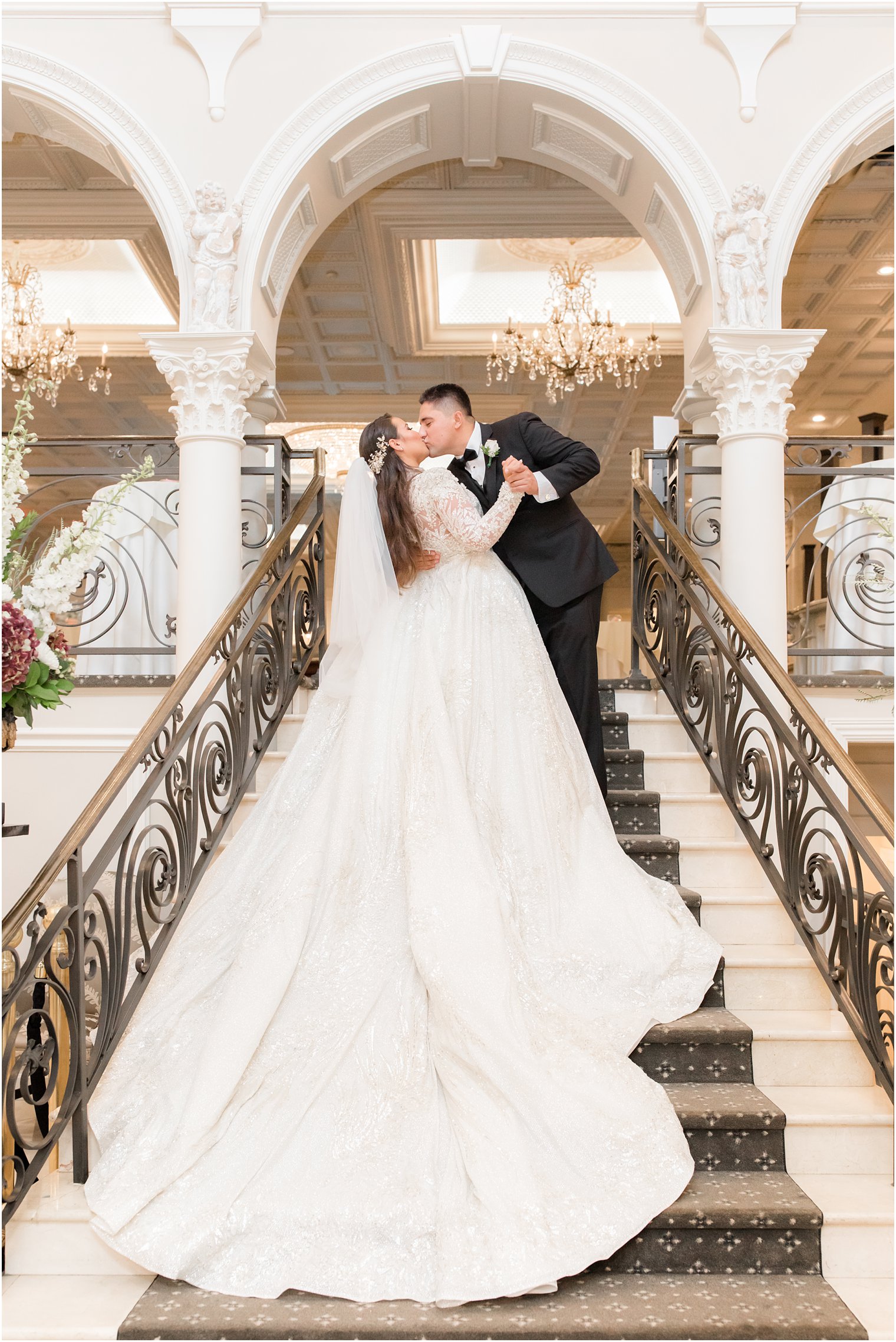 bride and groom kiss on grand staircase at Nanina's in the Park