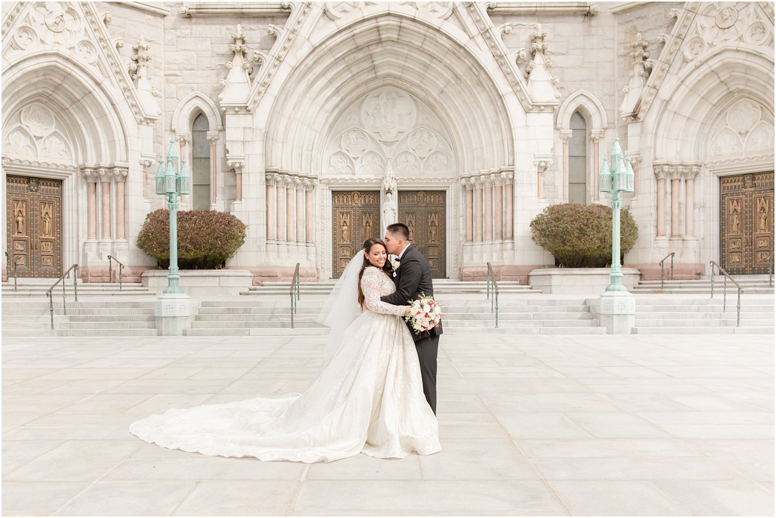 newlyweds stand together outside Cathedral Basilica of the Sacred Heart