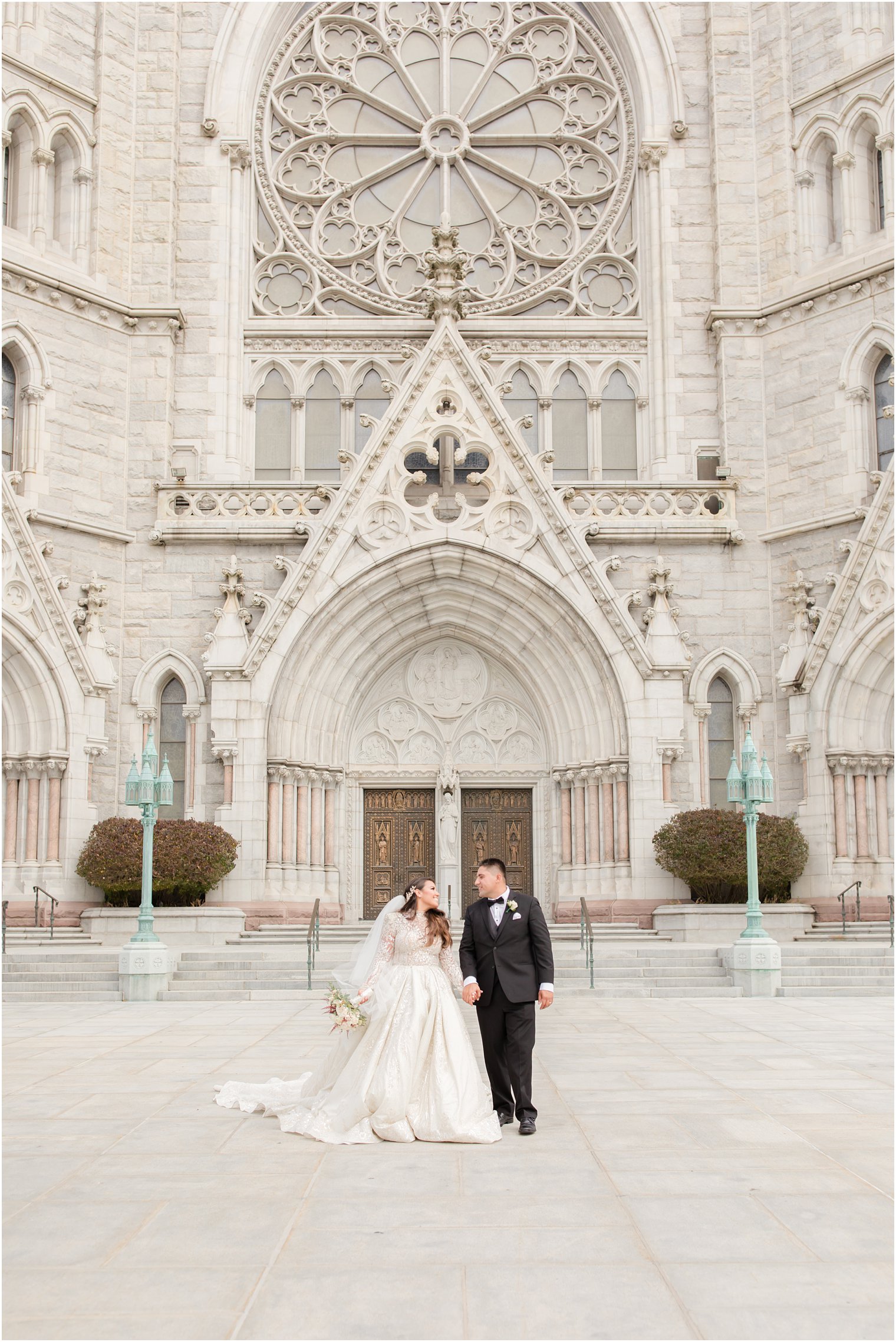 bride and groom walk outside Cathedral Basilica of the Sacred Heart