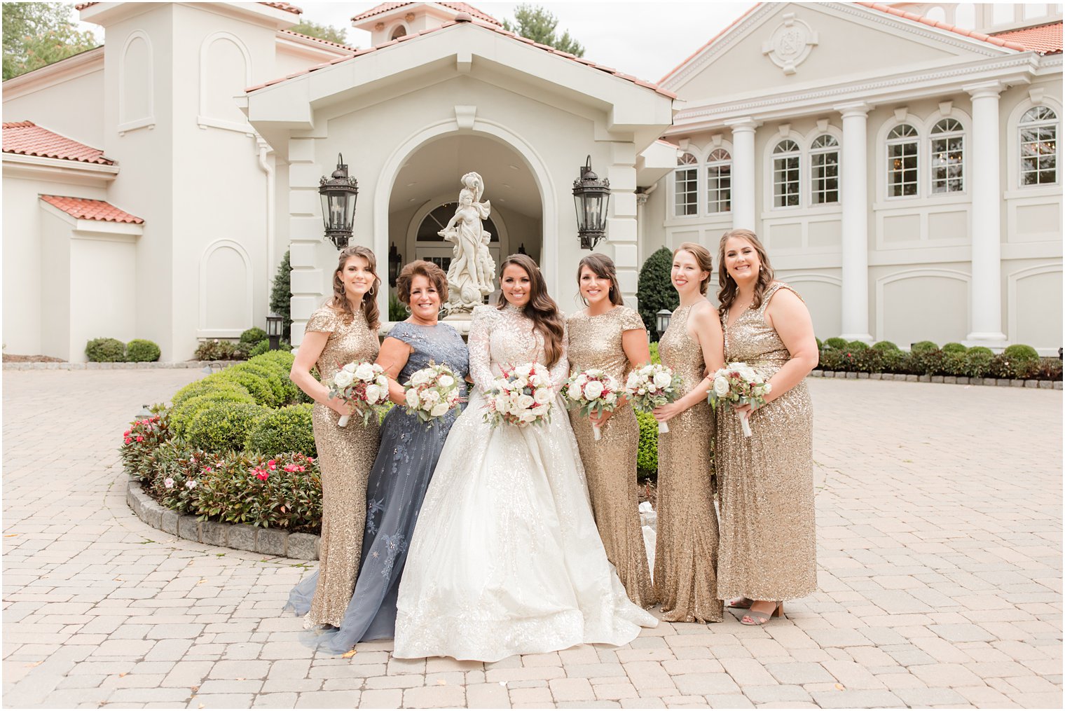 bride poses with bridesmaids in gold gowns outside Nanina's in the Park