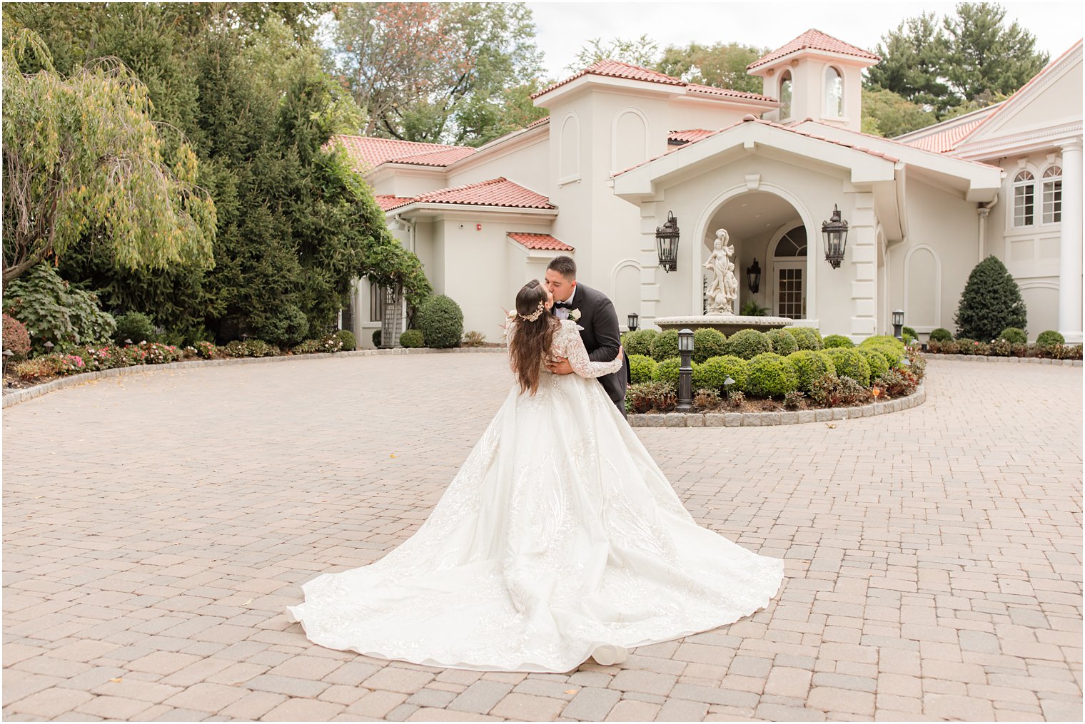 groom kisses bride with her spread out dress behind her