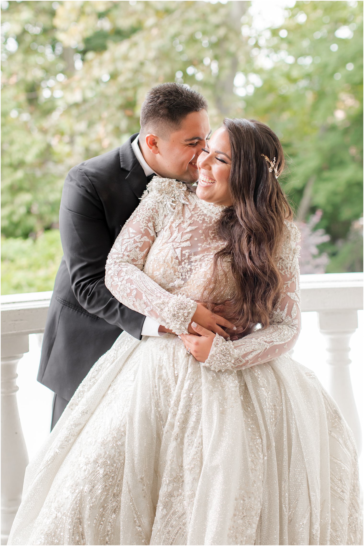 groom kisses bride and makes her laugh during wedding portraits