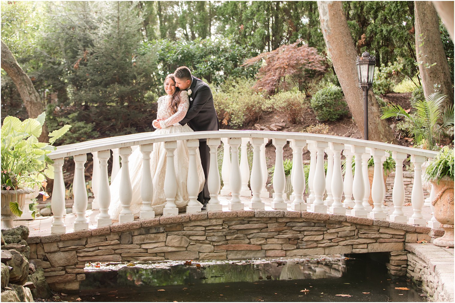 newlyweds pose on bridge at Nanina's in the Park