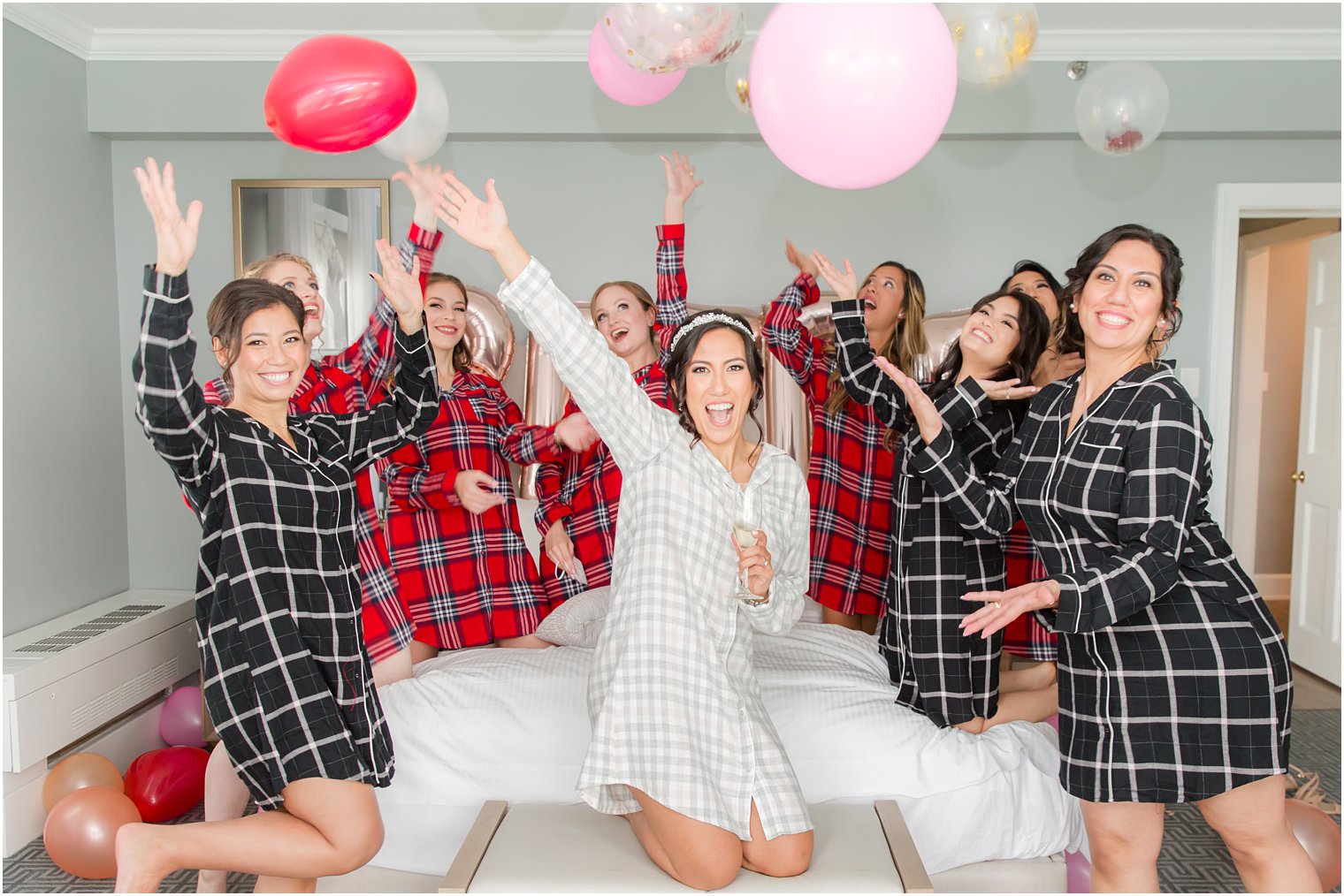 bride and bridesmaids throw balloons while getting ready