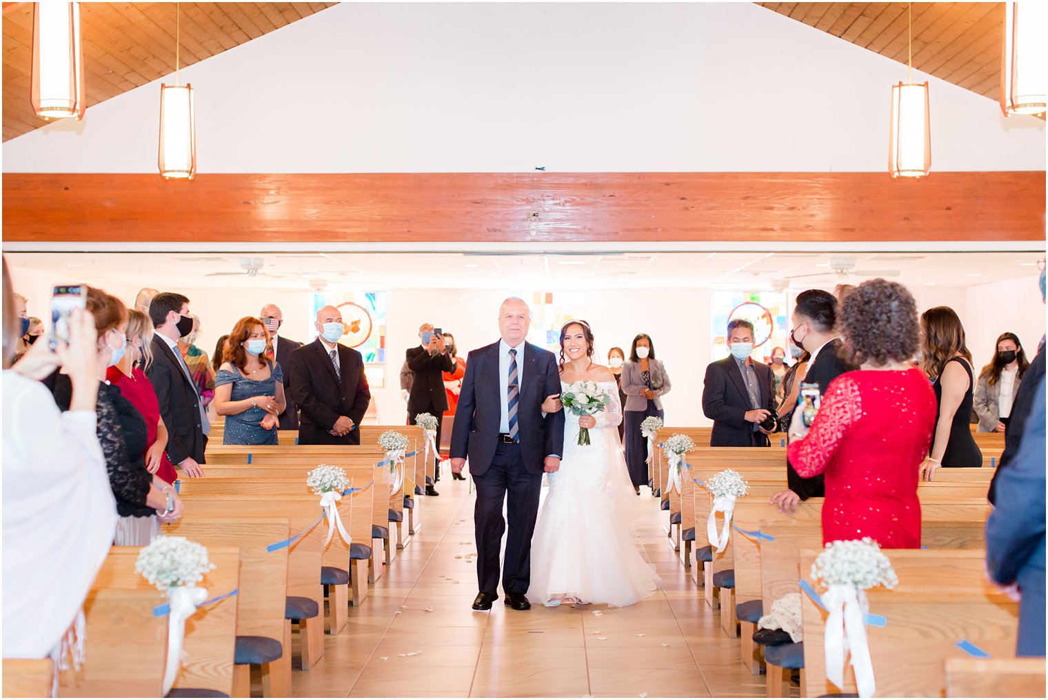 bride walks down aisle during traditional church wedding in New Jersey