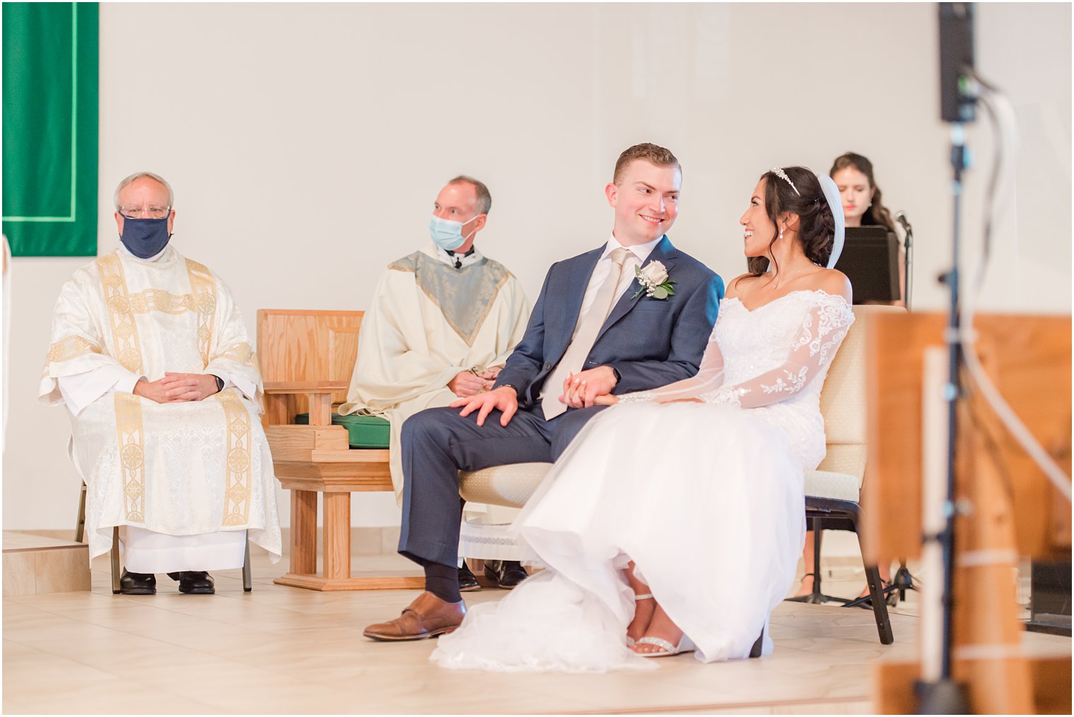 bride and groom sit together during traditional church wedding in New Jersey