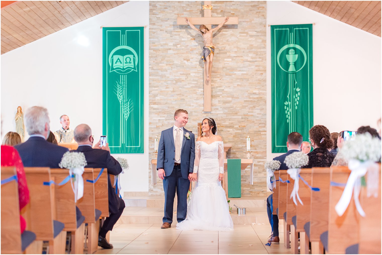 bride and groom look at wedding guests during traditional church wedding in New Jersey