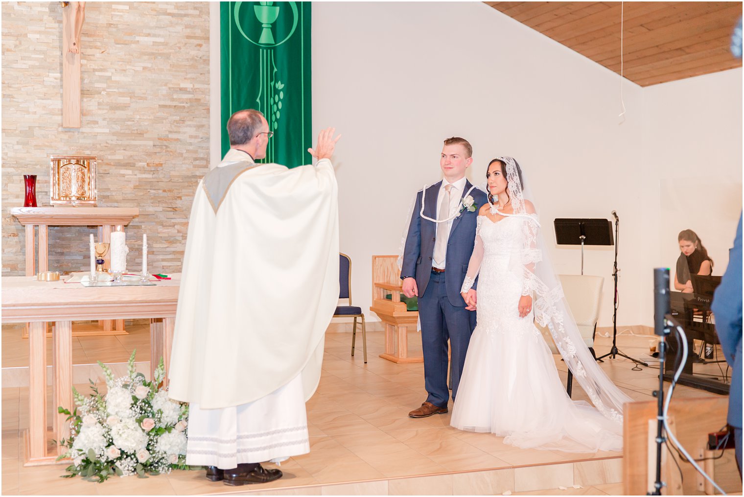 bride and groom are blessed after traditional church wedding in New Jersey