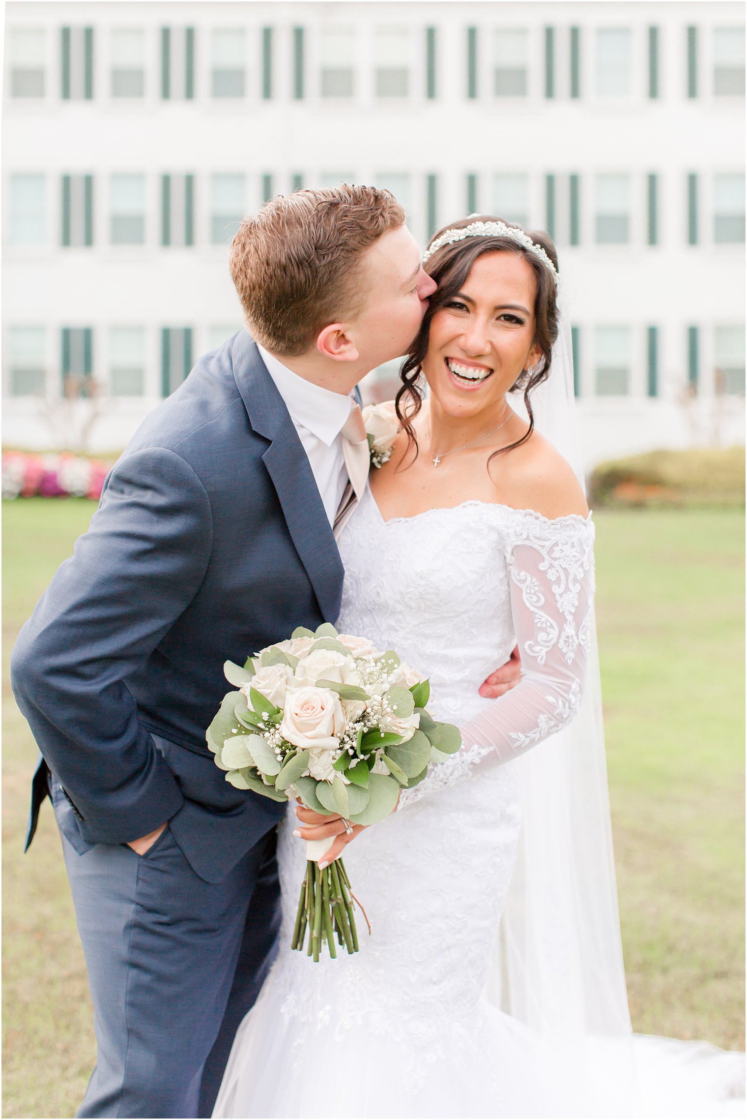 groom kisses bride on cheek during Seaview Hotel wedding photos