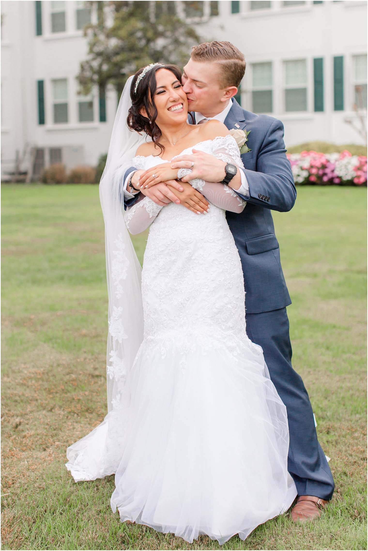 groom hugs bride from behind during wedding portraits in NJ