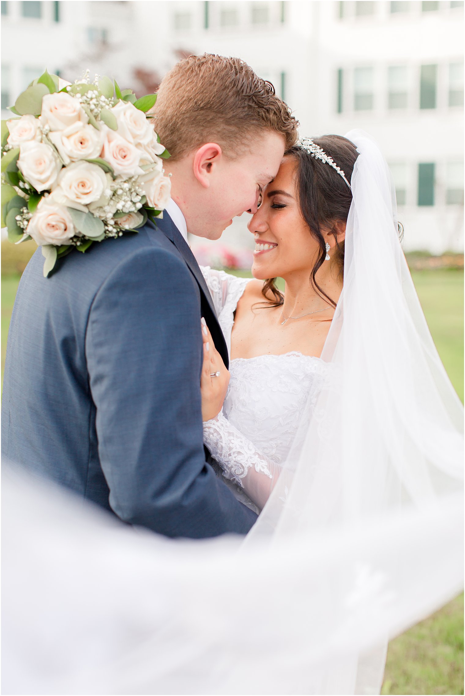 newlyweds stand nose to nose during Seaview Hotel wedding photos