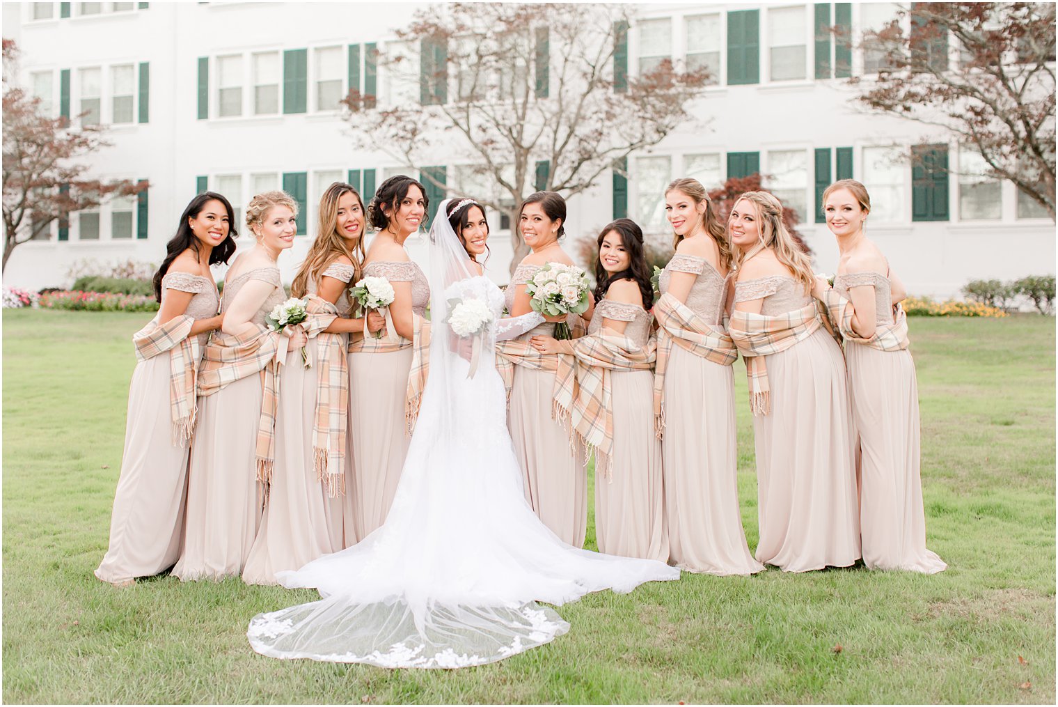 bridesmaids in pale pink gowns pose with plaid wraps before NJ wedding reception