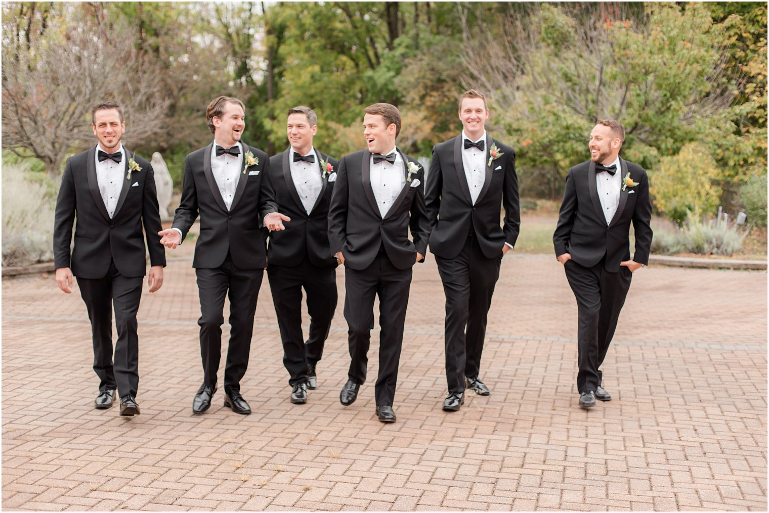 groom and groomsmen in black tuxes walk outside Conservatory at the Sussex County Fairgrounds