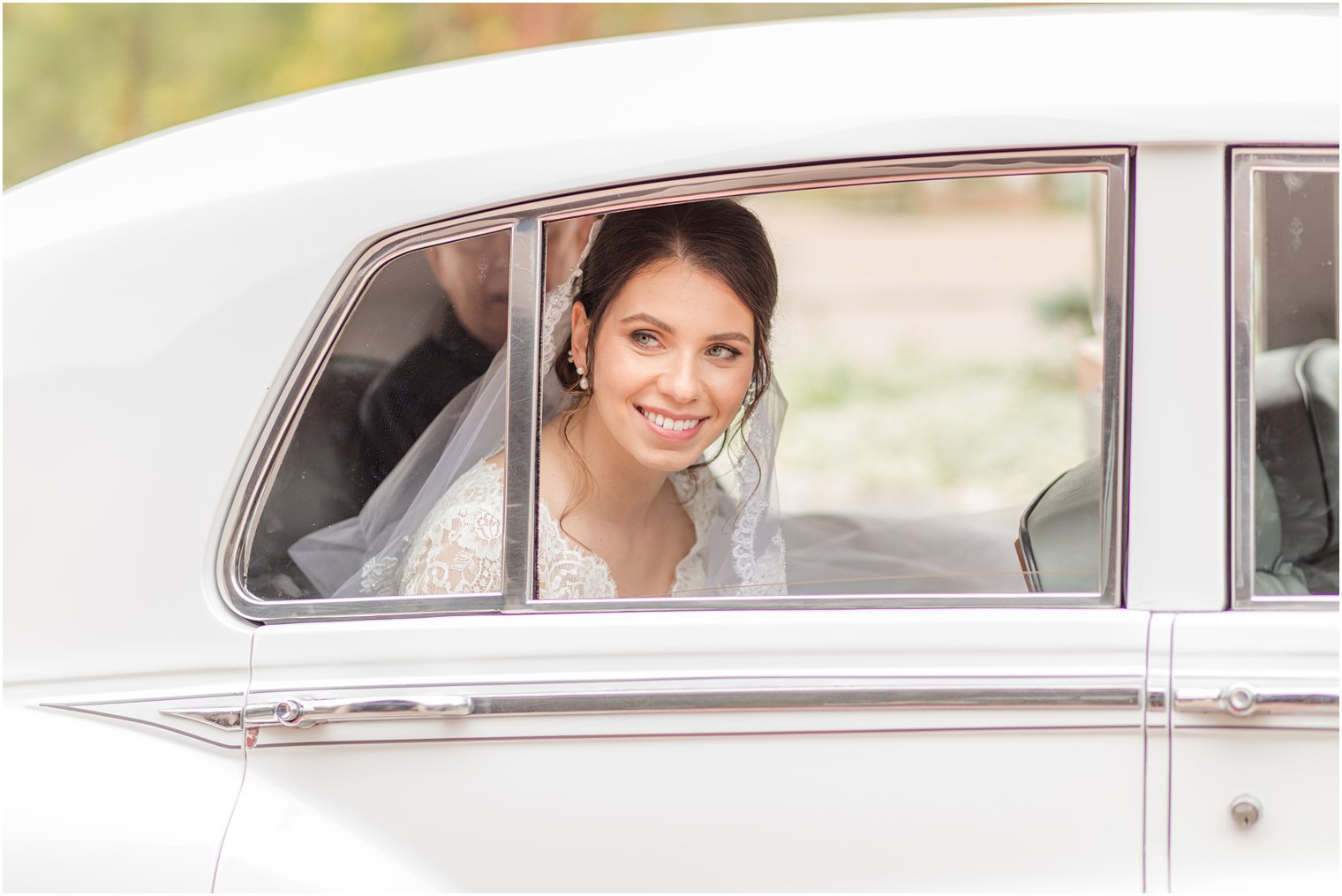 bride looks out window of white Bentley