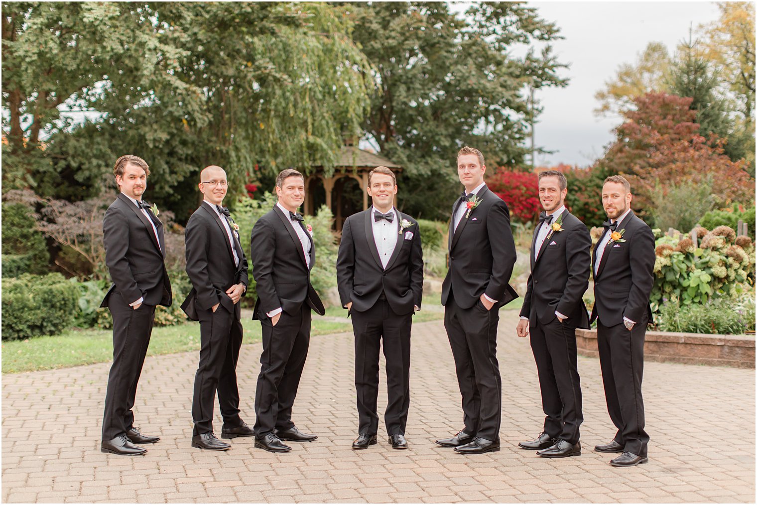 groomsmen in classic black tuxes pose in Conservatory at the Sussex County Fairgrounds