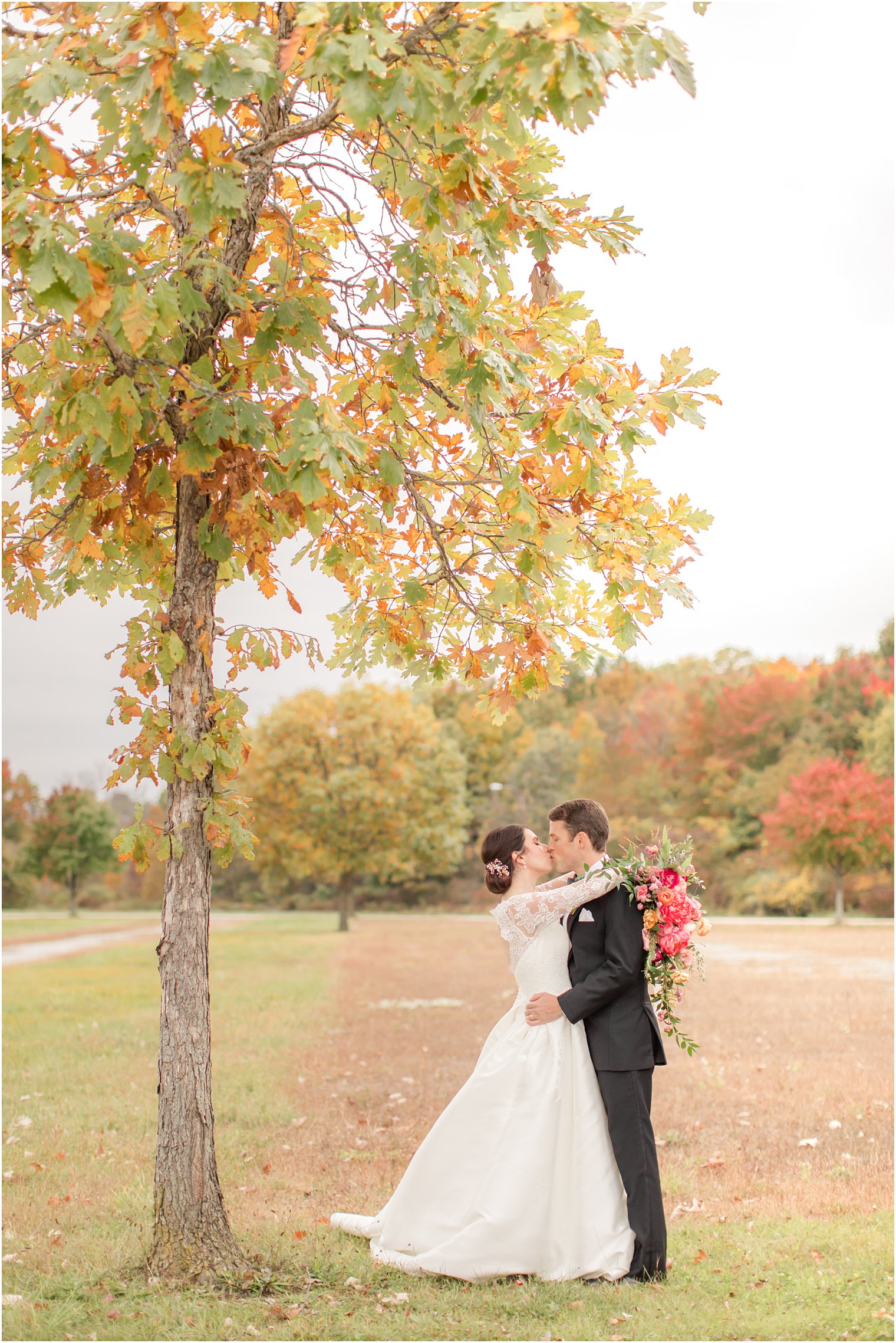 bride and groom kiss under tree in New Jersey