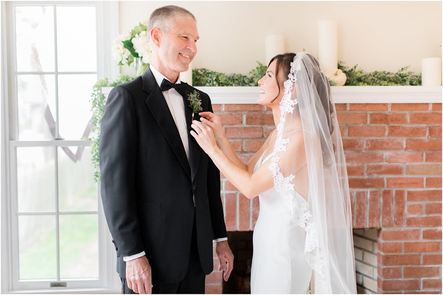 bride adjusts dad's boutonnière before wedding