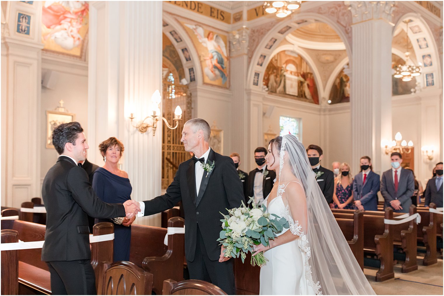 father of bride gives away bride during traditional church wedding at St. Catharine's Church in Spring Lake NJ