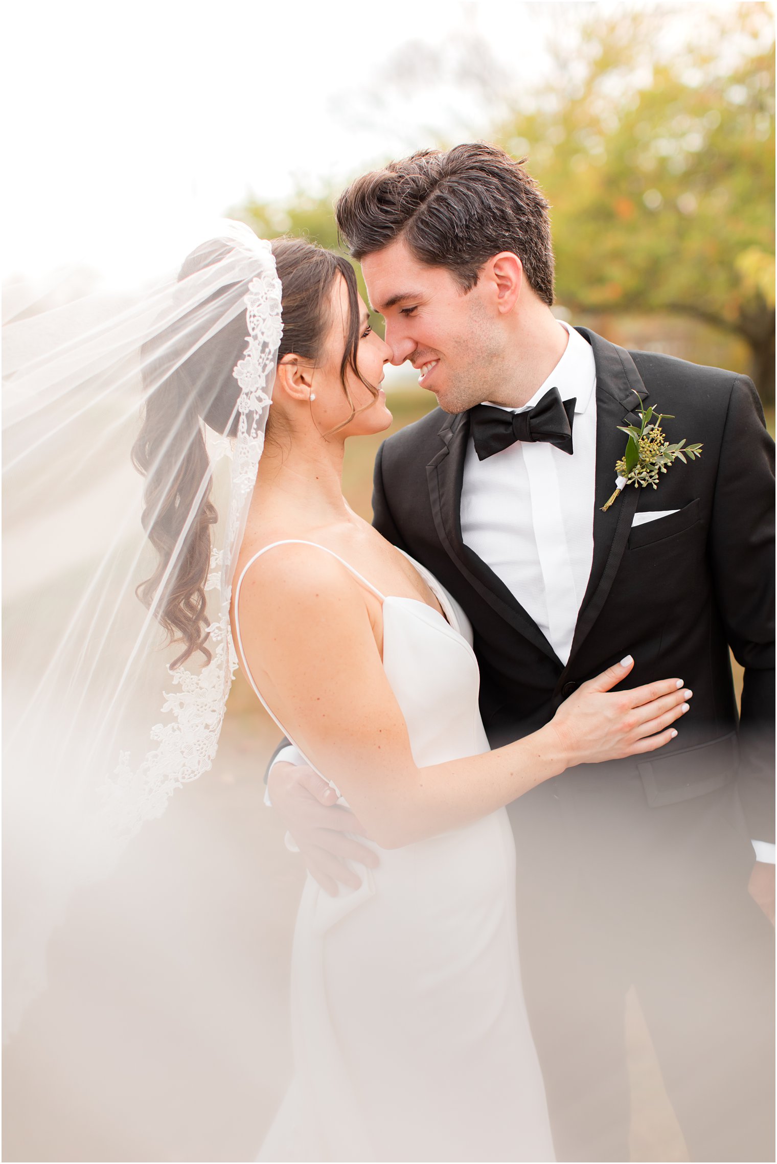 newlyweds stand nose to nose in Divine Park in Spring Lake NJ