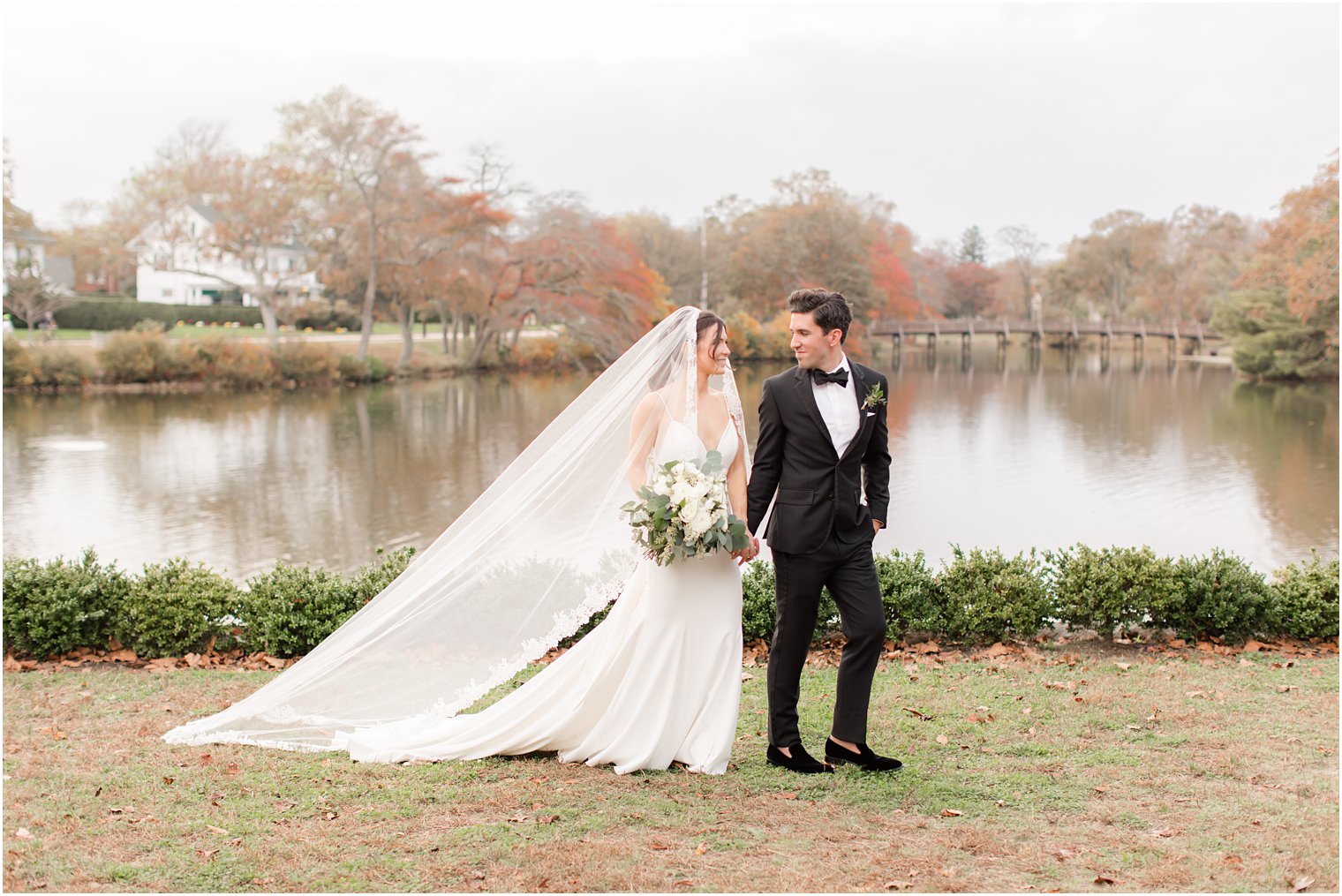 bride and groom walk along lake in Spring Lake NJ