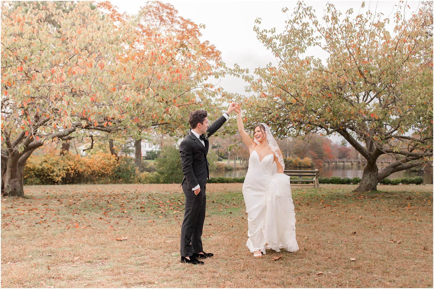 groom twirls bride during NJ wedding photos in the fall