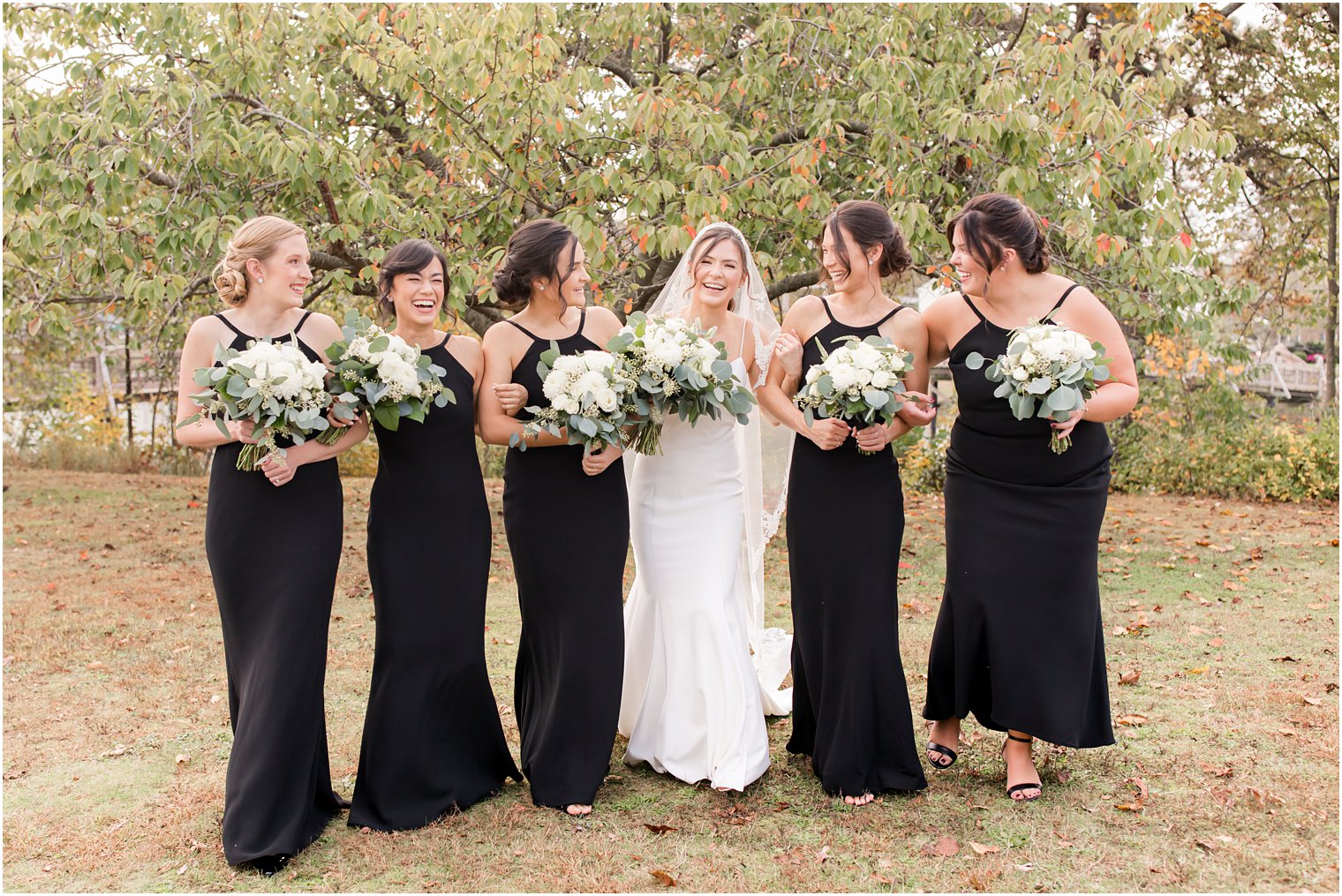bride walks with 5 bridesmaids in black gowns
