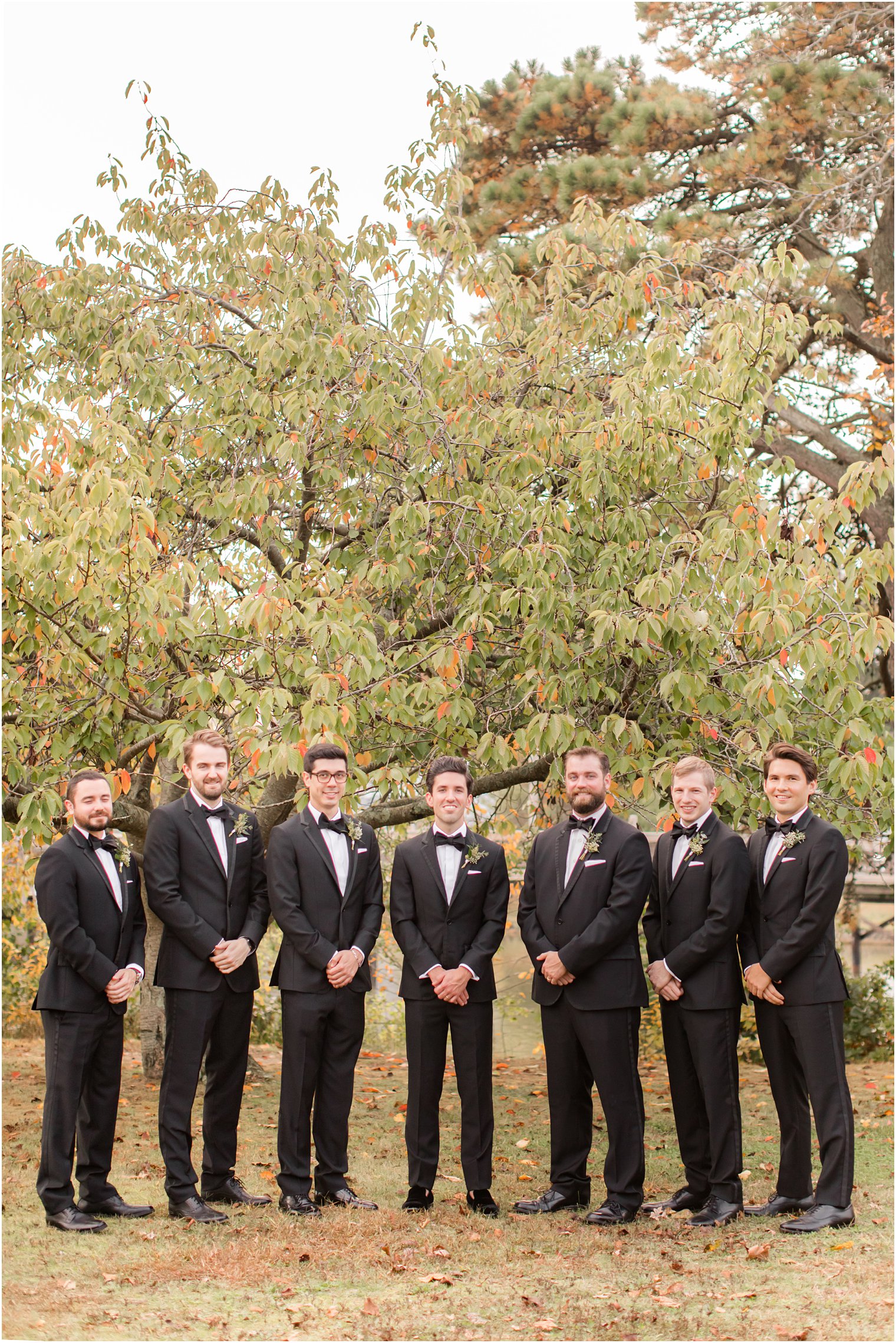 groom poses with 6 groomsmen in Divine Park before fall wedding