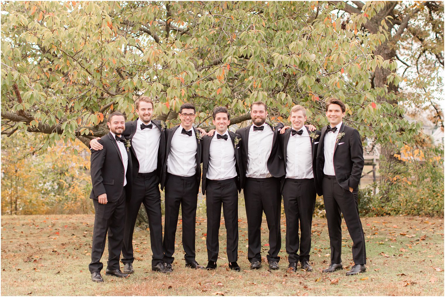 groom poses with groomsmen in tuxes before The Mill Lakeside Manor wedding