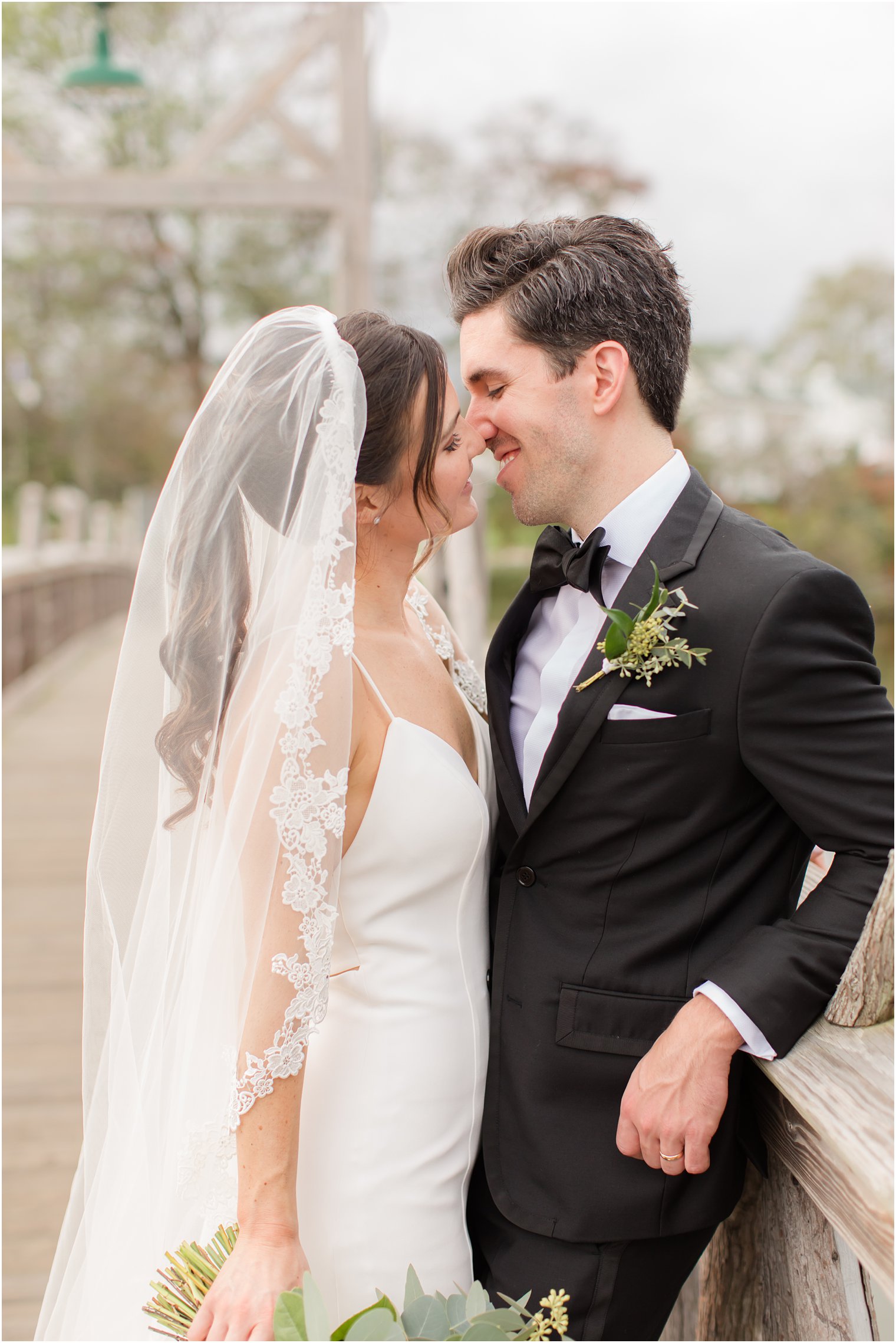 bride in modern wedding gown leans against groom in Spring Lake NJ