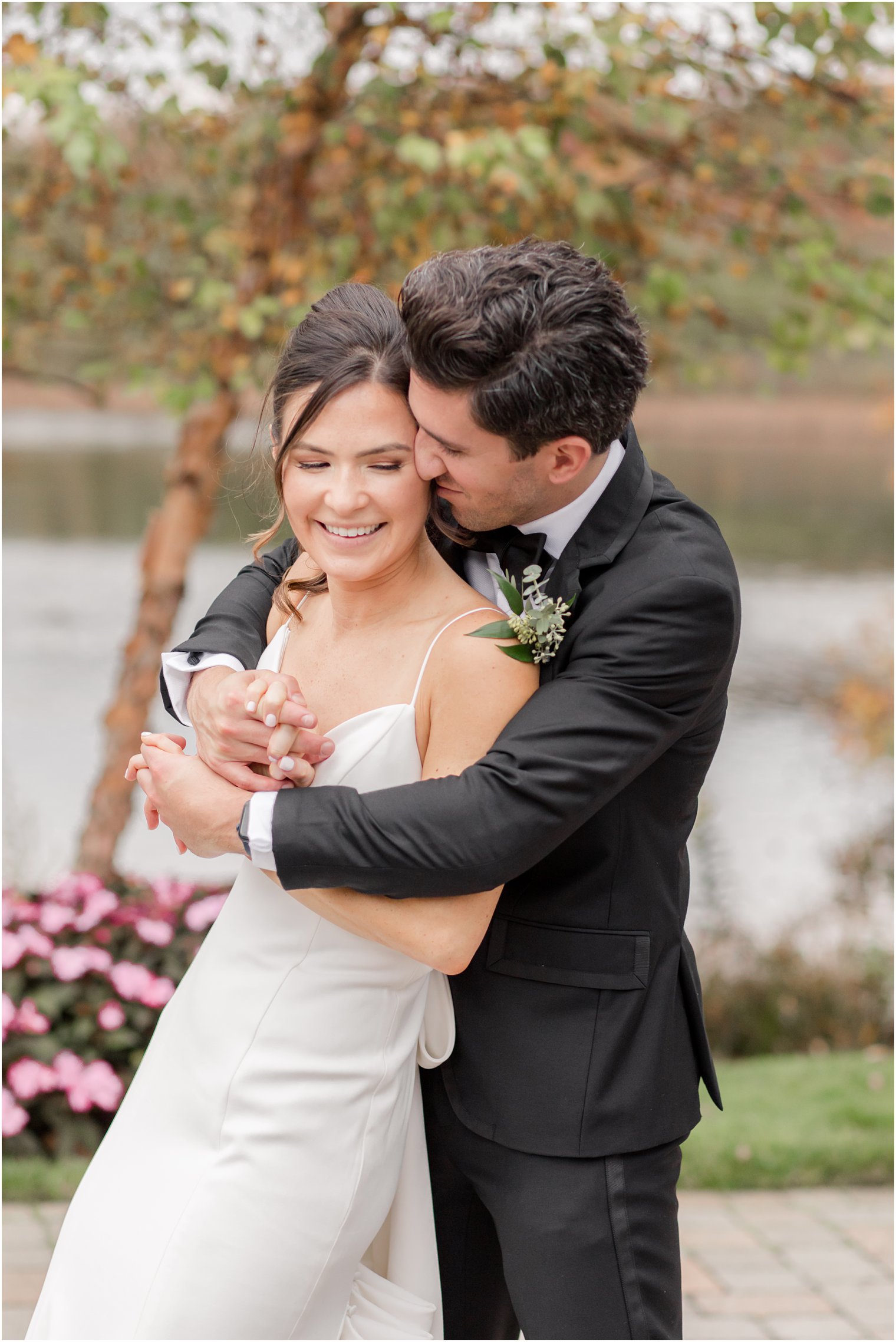 groom hugs bride during fall wedding portraits at The Mill Lakeside Manor Wedding
