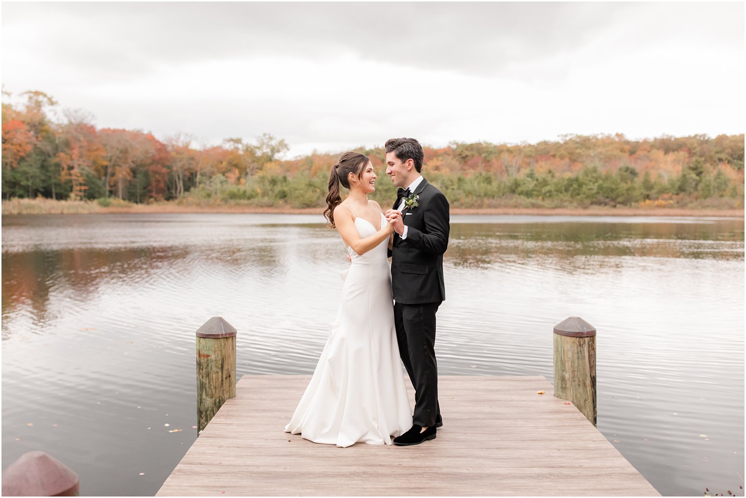 newlyweds dance on dock outside The Mill Lakeside Manor