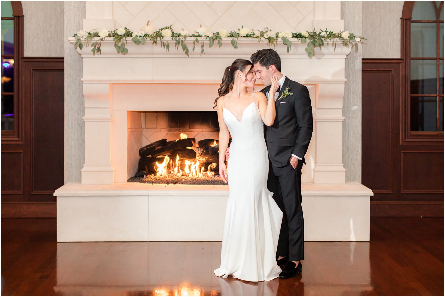 bride and groom pose in front of fireplace at The Mill Lakeside Manor wedding
