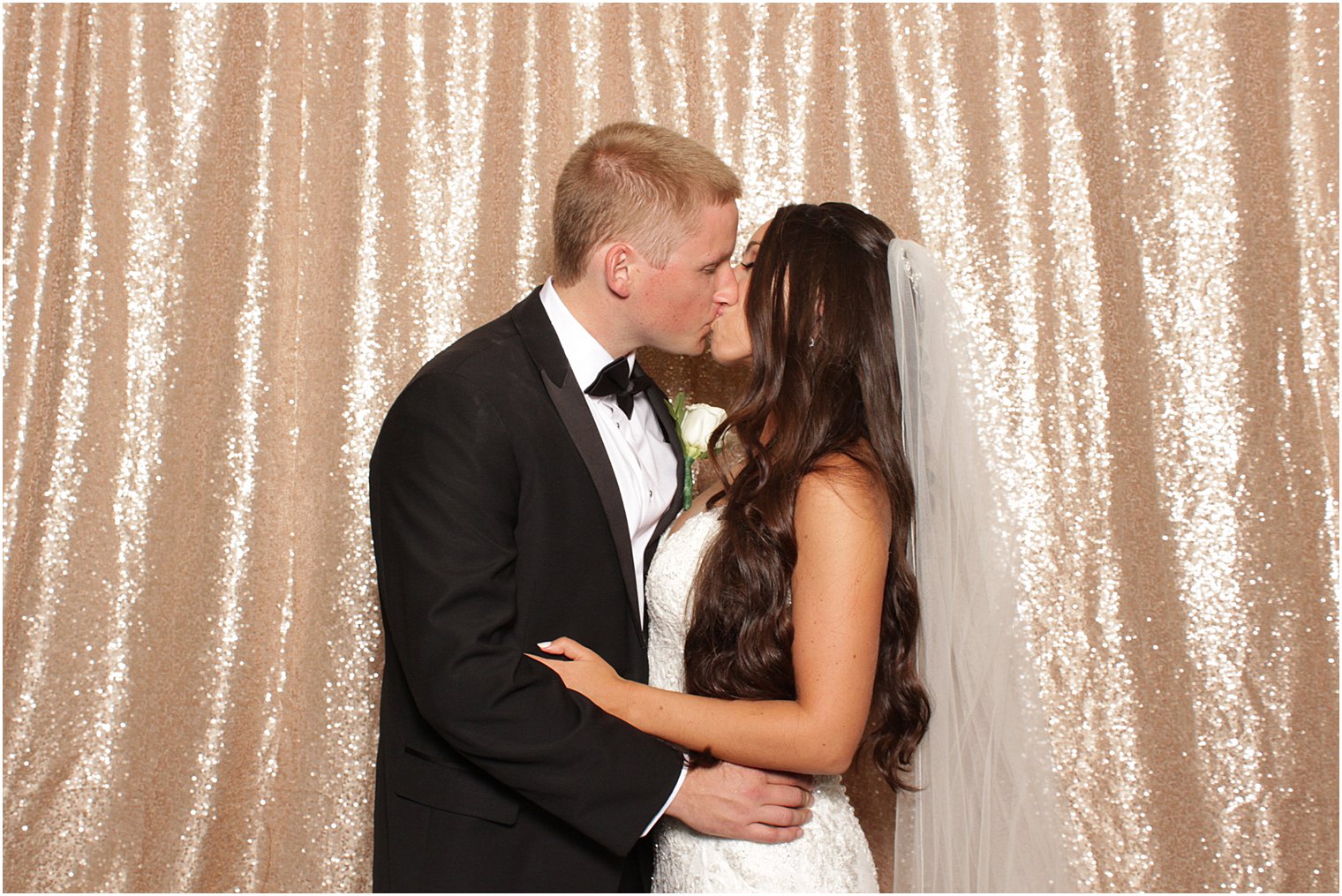 bride and groom kiss in photobooth
