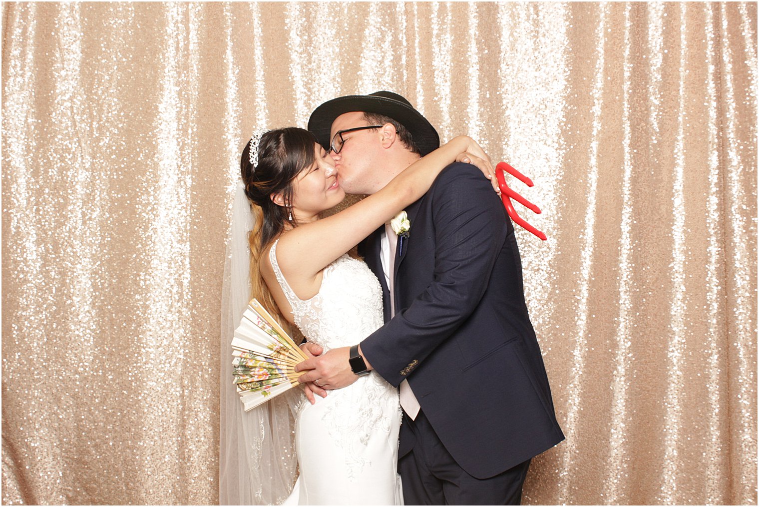 groom kisses bride in the photo booth
