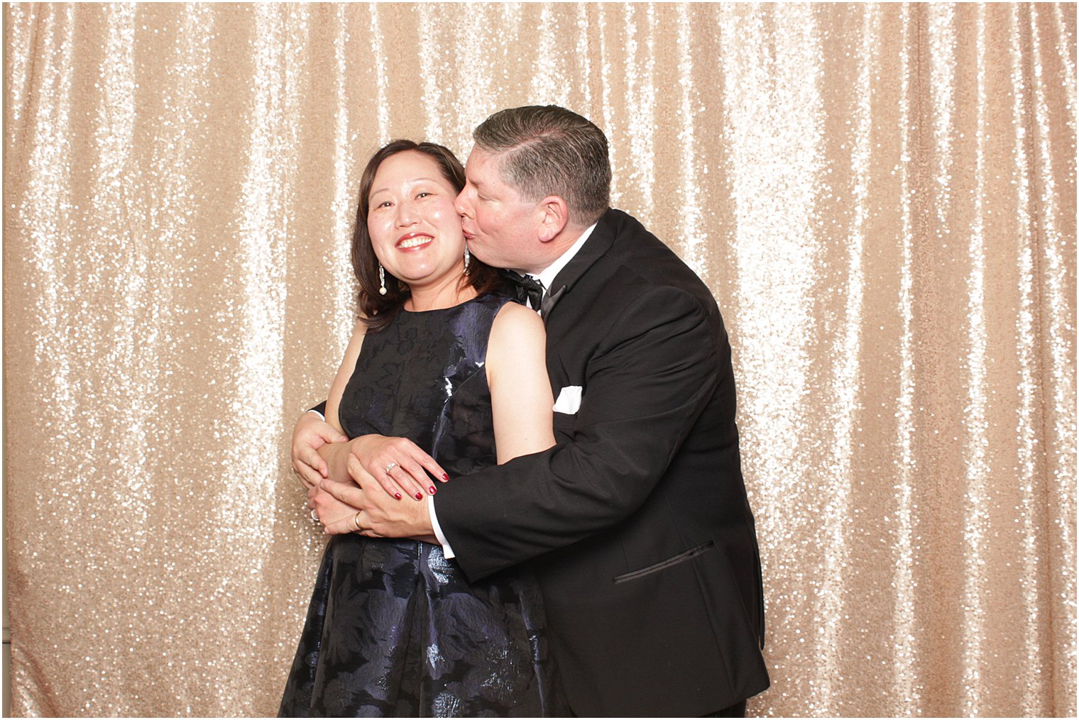 guests hug in photo booth at Lake Mohawk Country Club