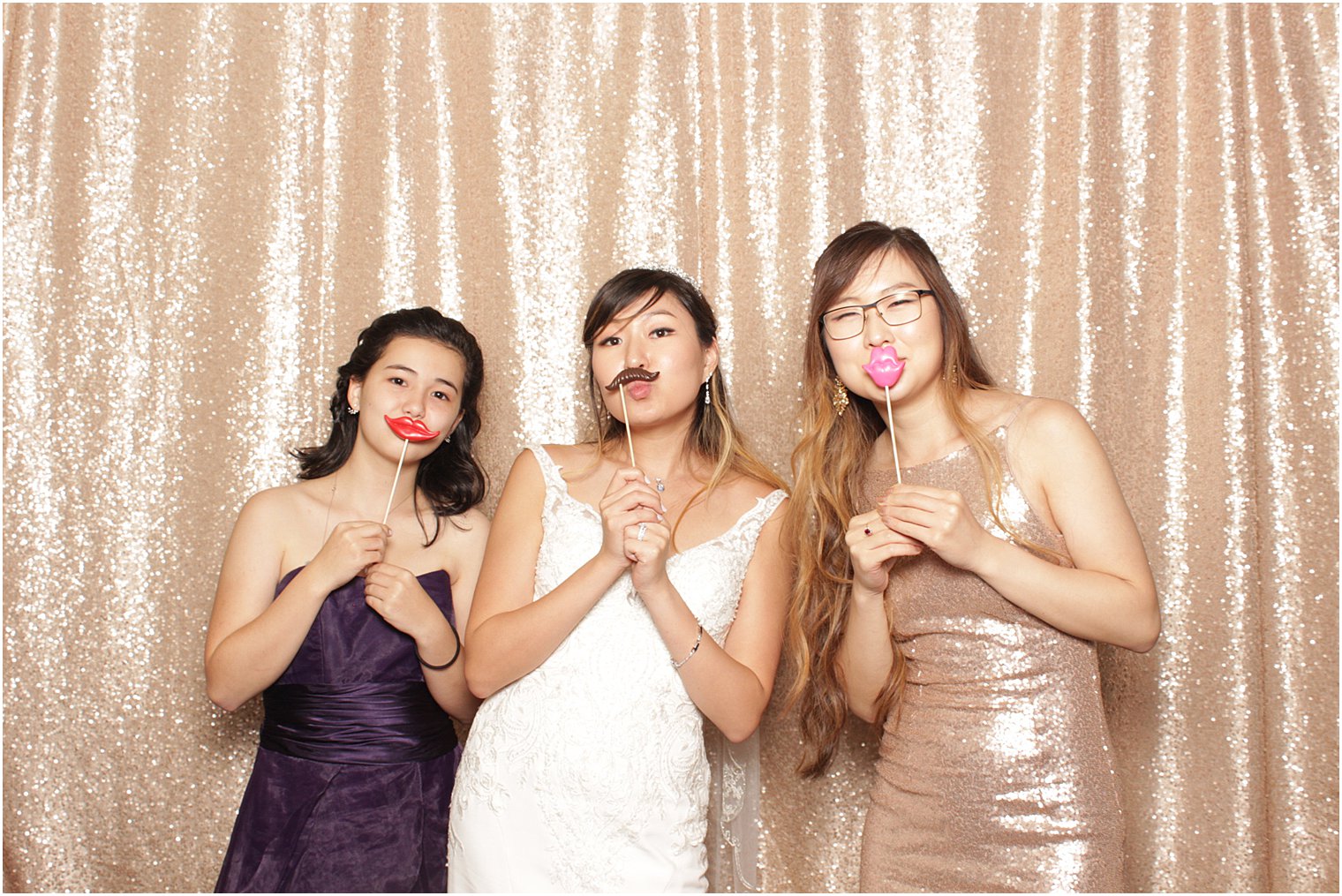 bride plays in photo booth with bridesmaid