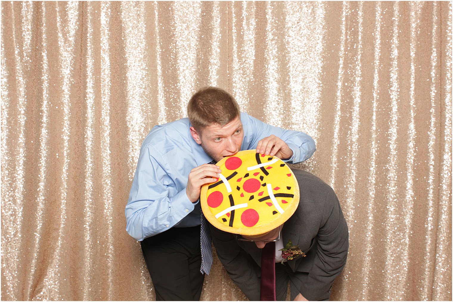 guest eats pizza hat on another wedding guest during Park Chateau Estate Photo Booth