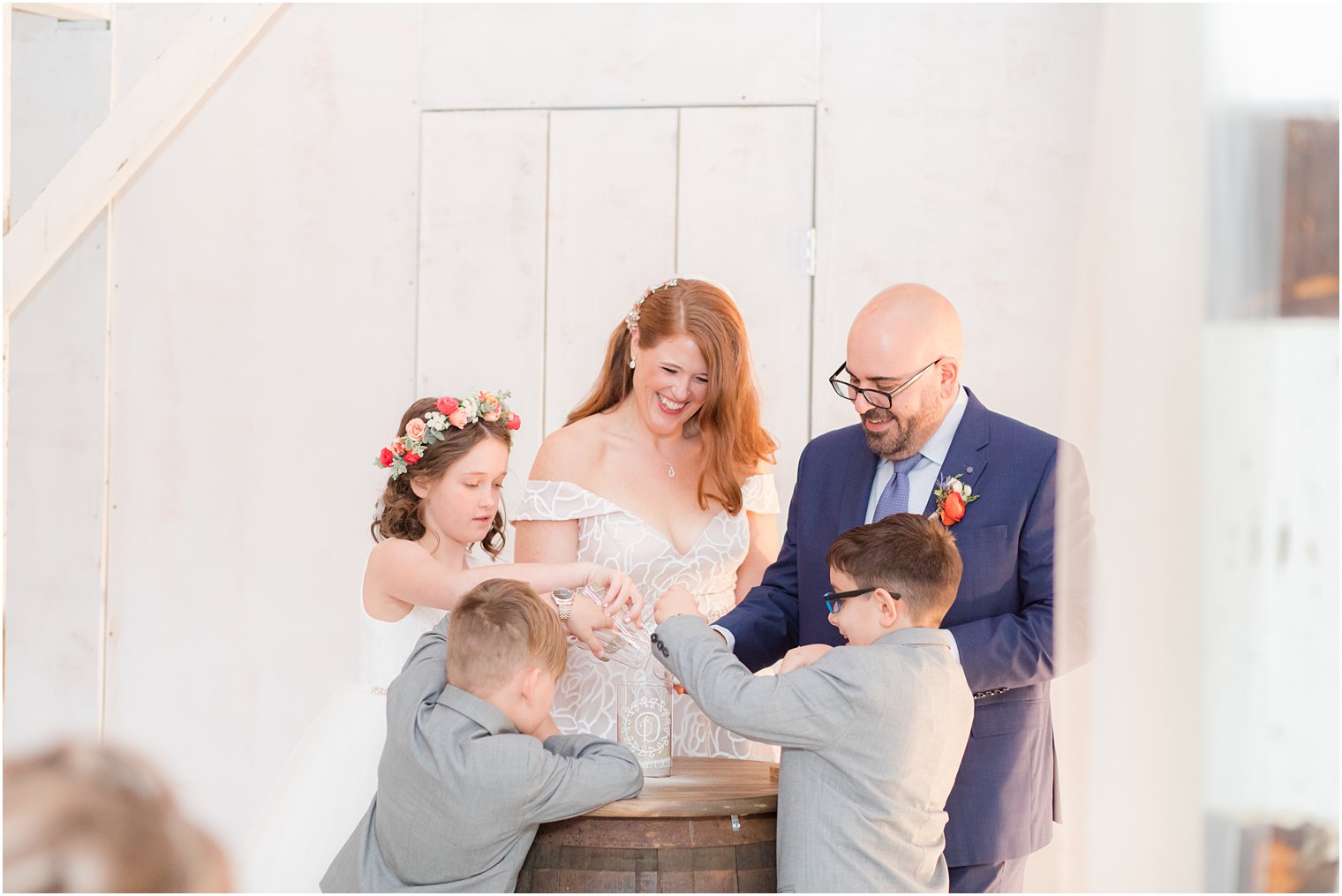 bride and groom complete sand ceremony with children at wedding ceremony